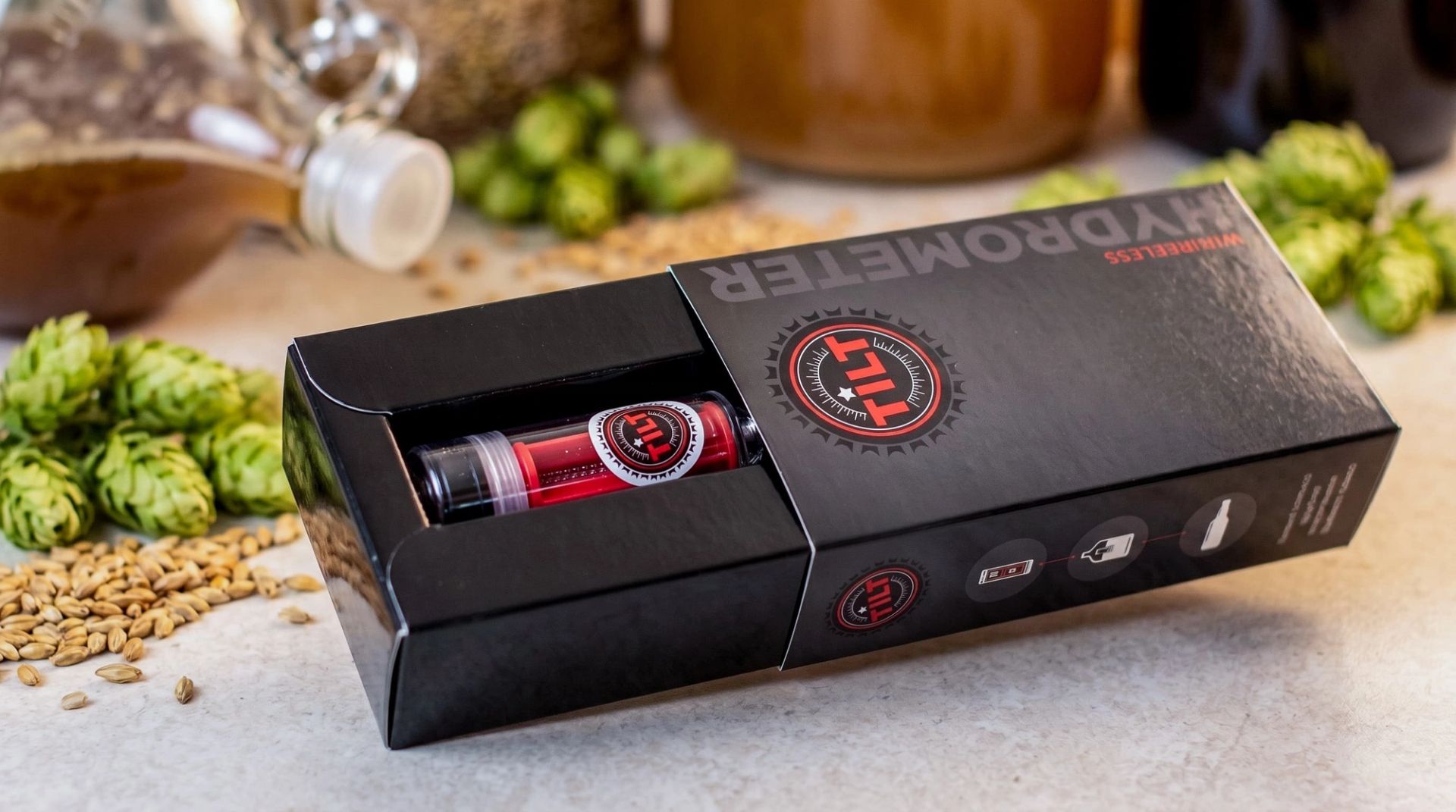 TILT Wireless Hydrometer box partially slid open, revealing the red cylindrical device nested securely inside.