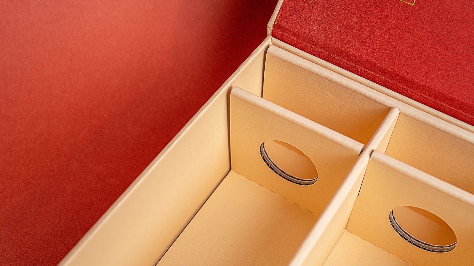 Close-up of the custom cream corrugated packaging insert with circular cutouts for cocktail bottles.