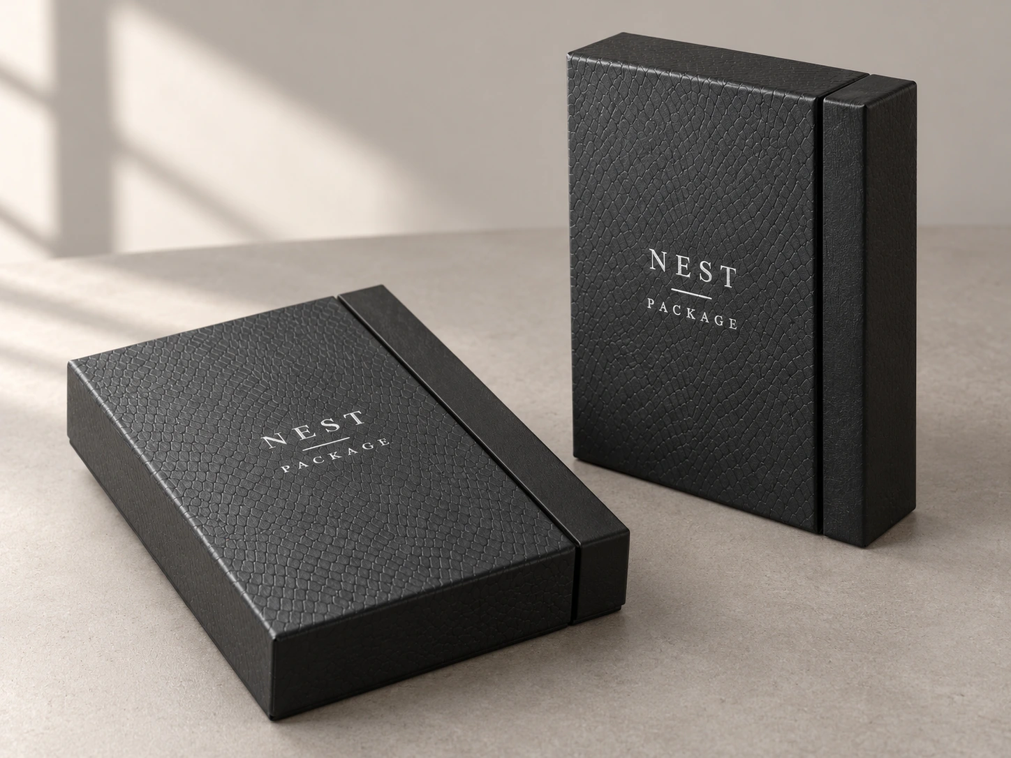 Two black leather textured presentation boxes resting on a tabletop